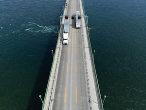 This aerial view shows trucks passing over the Peace Bridge between Canada and the US in Fort Erie, Ontario, on August 18, 2026. Canada's Prime Minister Mark Carney has held urgent talks with US President Donald Trump, Ottawa confirmed on August 18, in an effort to avoid fresh US tariffs on Canadian goods as a midnight deadline fast approaches. Trump signed orders for the steep 50-percent duties last month, with the White House alleging "discriminatory treatment" by Canada against US alcohol, automobile and dairy products. (Photo by Cole BURSTON / AFP via Getty Images)
